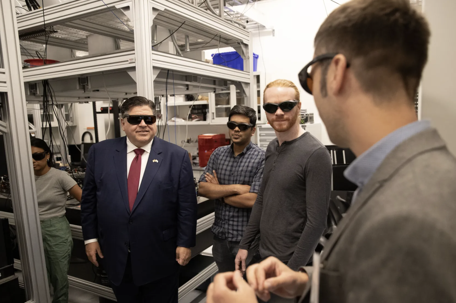 Gov. JB Pritzker listens to researchers explain their work in one of the University of Chicago quantum engineering laboratories in July 2023.<br/>
