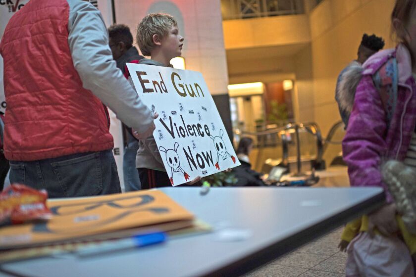 A schoolboy displays the poster he designed at an event held at Washington’s Union Station on the eve of the “March for our lives” rally. | AFP/Getty Images