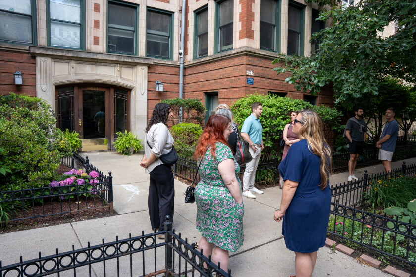 Potential homebuyers and their agents wait outside of an open house in June for a one-bedroom condo in Lake View.