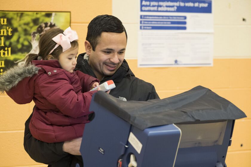 25th ward aldermanic candidate, Alexander “Alex” Acevedo with daughter, Ava, casts his ballot at Ruiz Elementary School. | Rick Majewski/For the Sun-Times