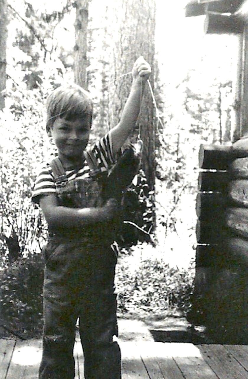 John Maclean, author of “Home Waters,” on the porch of the cabin at Seeley Lake with a largemouth bass, 1947. Credit: John Maclean’s personal collection
