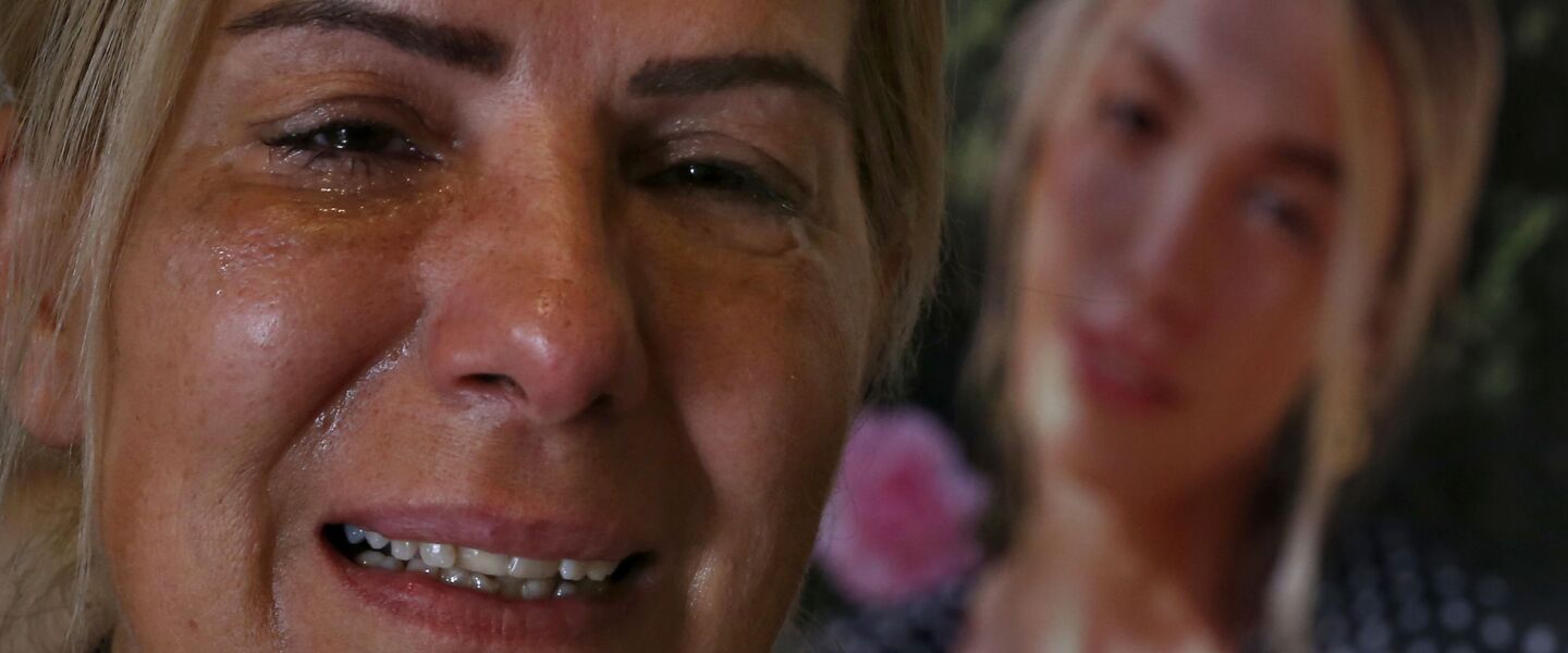 Chouchan Yeghiyan weeps in front of a picture of her daughter Jessica Bezdjian, who was killed in last year’s massive blast at Beirut’s seaport. Bezidjian was one of four female nurses whose lost their lives at the Saint George Hospital University Medical Center that day, including her close friend Jessica Kahwaji.