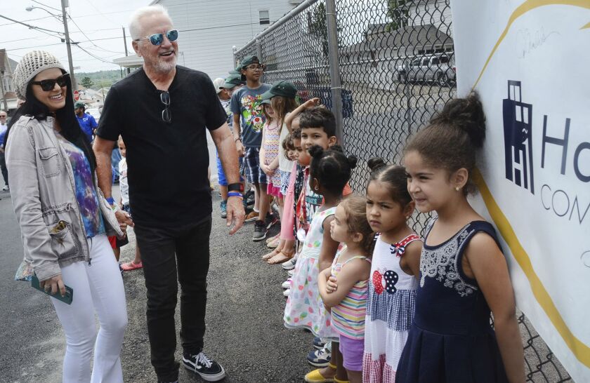 Chicago Cubs Manager Joe Maddon and his wife Jaye are all smiles as they see the new playground at the Hazleton One Community Center and the day care children waiting for it to open in Hazleton, Pa. | Ellen F. O’Connell/Associated Press