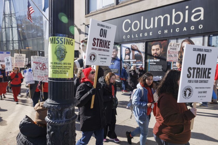 A Missing poster depicting President and CEO of Columbia College-Chicago Dr. Kwang-Wu Kim is taped on a pole as faculty and students carry signs during a strike by Part-time adjunct faculty members at Columbia College at 600 S Michigan Ave in the Loop, Monday, Oct. 30, 2023.