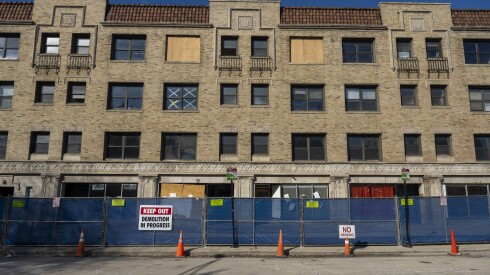 A sign saying "Keep out. Demolition in progress" hangs from a fence surrounding 1224 W. Loyola Ave.