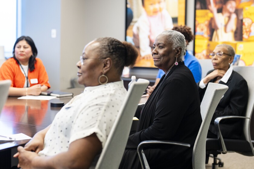 Sharon Hendrix Phillips, a program participant of Easterseals’ Senior Community Service Employment Porgram, center, sits at a conference table at Easterseals' office in the Loop.