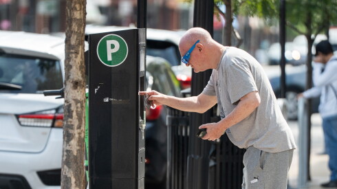 A driver pays for parking at a ParkChicago machine on North Clark Street in Andersonville, Tuesday, Sept. 15, 2026.