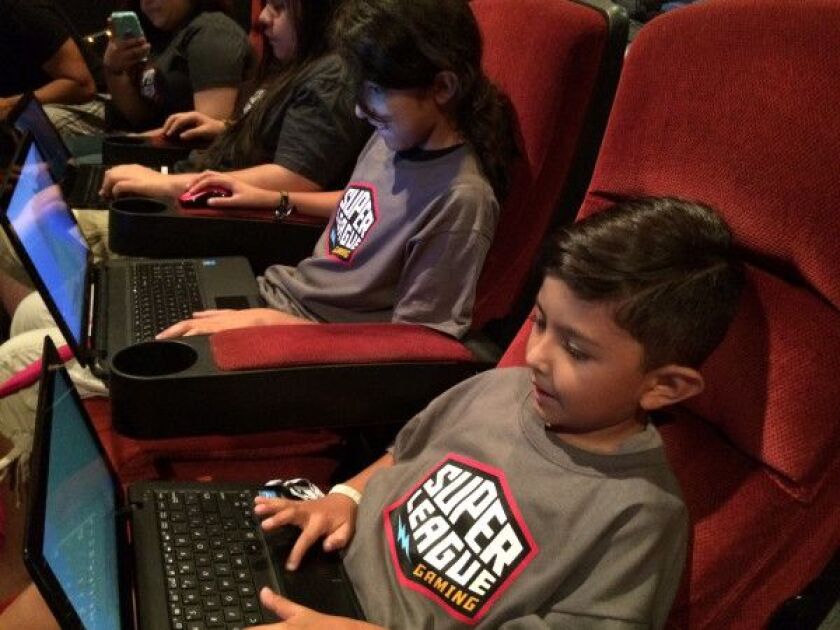 Eddie Franco, 6, and his sister Christina, 12, are all smiles as they play Minecraft at a Super League Gaming in-theater tour stop at AMC River East theaters on Tuesday, July 28, 2015. | MIRIAM DI NUNZIO/FOR THE SUN-TIMES