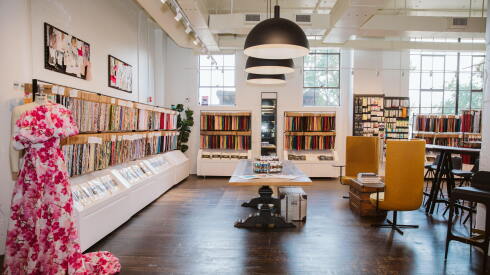 Inside the Atlanta showroom of Mood Fabrics, with fabric samples hanging along the wall, chairs and seating.
