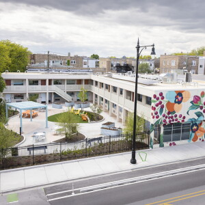 Aerial view of the former Diplomat Motel, 5230 N. Lincoln Ave., showing a courtyard with greenery and a mural with flowers on the side of the building.