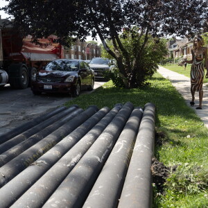 A resident walks near pipes in the 1400 block of North Linder Avenue in Austin.