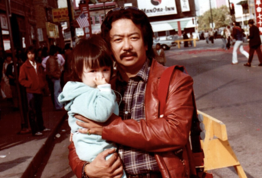 Mr. Woo in Chinatown holding his goddaughter.