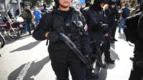 Police officers are seen along a street in Caracas Saturday after U.S. forces captured Venezuelan leader Nicolas Maduro.