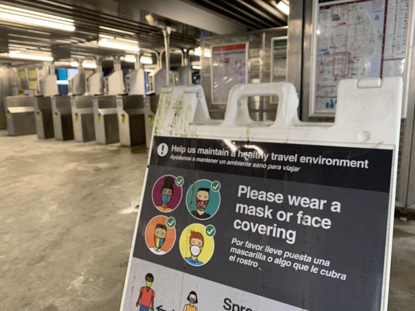 A sign at the CTA Red Line station at Lake Street in the Loop on Tuesday, Feb. 2, 2021 urges riders to wear face masks.