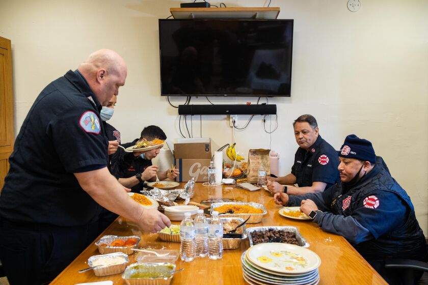 Chicago Fire Department firefighters at Engine 29 in Bridgeport eat food that was donated Thursday by White Sox pitcher Liam Hendriks and his wife Kristi.