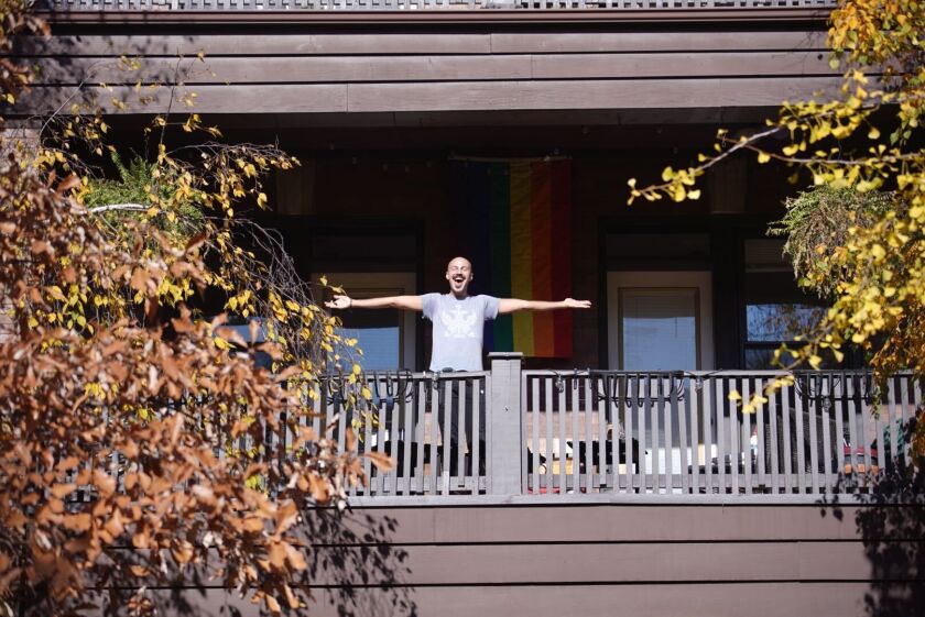 Pawel Drozda celebrates the election of Joe Biden on his balcony in Buena Park.