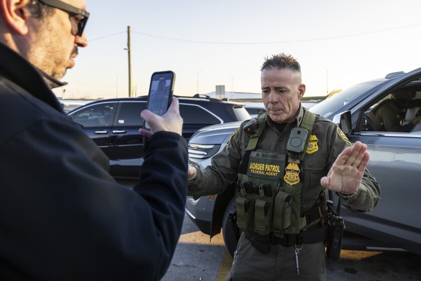 U.S. Border Patrol Cmdr. Gregory Bovino pushes members of the media away as federal immigration enforcement agents perform a checkpoint and detain individuals in a rideshare lot near Balmoral Avenue and Mannheim Road in Rosemont near O’Hare International Airport, Wednesday, Dec. 17, 2025.