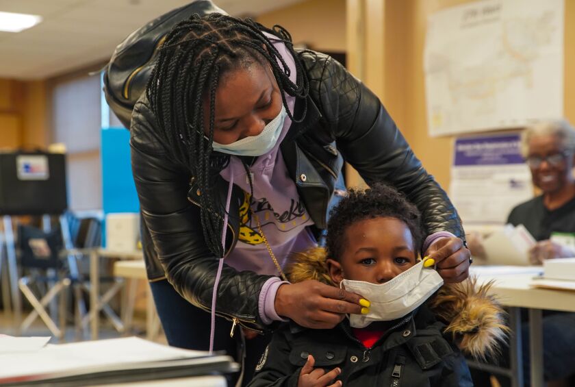 Nikolette Baxter, 30, and her 2-year-old son Jeremy, both of the West Side, masked up when Baxter came to vote in the Illinois primary election at Midwest Terrace senior apartments at 150 S. Campbell Ave on the Near West Side, Tuesday afternoon, March 17, 2020