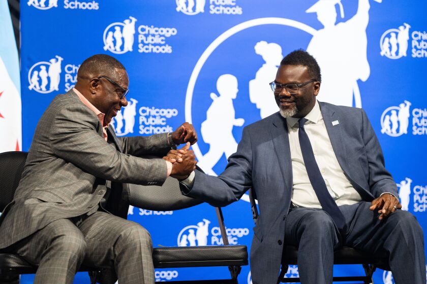 Chicago Mayor Brandon Johnson (right) and Gregory Sain, Chicago Public Schools’ director of community safety and relations, sit together during a celebration of Safe Passage workers at Wintrust Arena in the South Loop on Tuesday, Aug. 15, 2023.