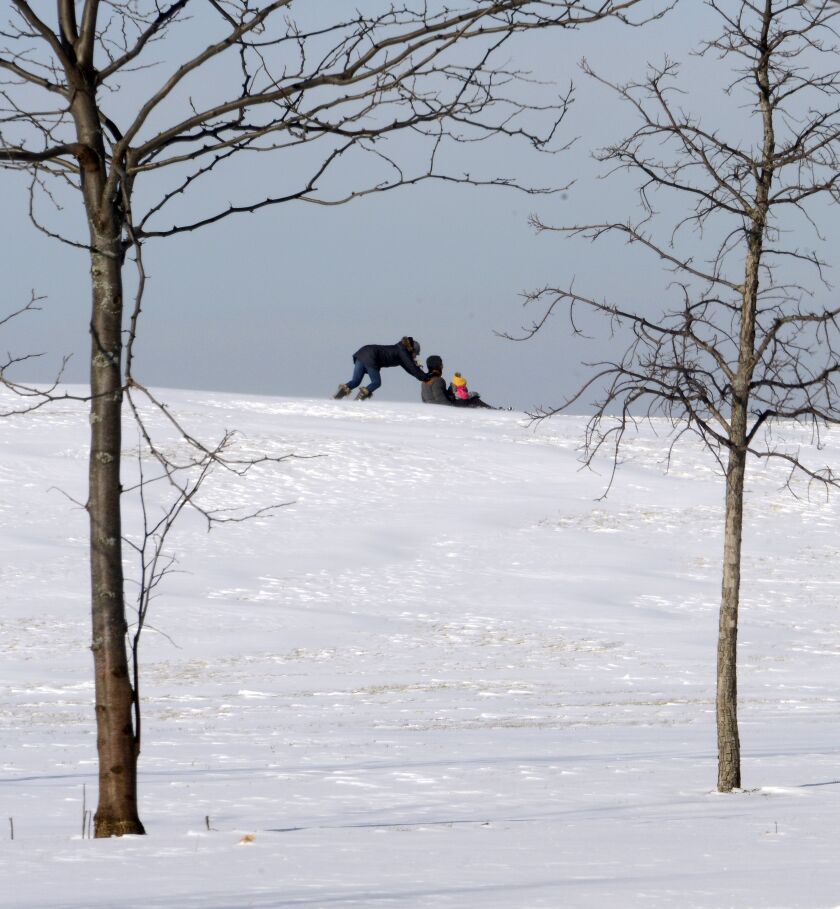 People on a sled get a boost on the hill at Wilson and Simonds Drive near the lakefront on Tuesday afternoon. | Michael Schmidt/Sun-Times