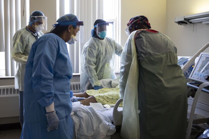 Doctors and nurses tend to a woman suffering from COVID-19 at Roseland Community Hospital on the Far South Side in April.