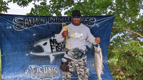 Larry Powell sports his second championship belt in three years and hoists the winning salmon Saturday at Jackson Park during the Slamming Salmon Nightmare Fishing LLC Tournament. Credit: Dale Bowman