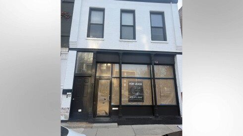 Exterior of the retail space at 2118 N. Halsted St., with a "For Lease" sign and windows covered with brown paper.