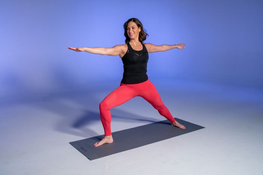 Health and fitness expert Stephanie Mansour in yoga pose Warrior II, the first step in working towards Bird of Paradise.