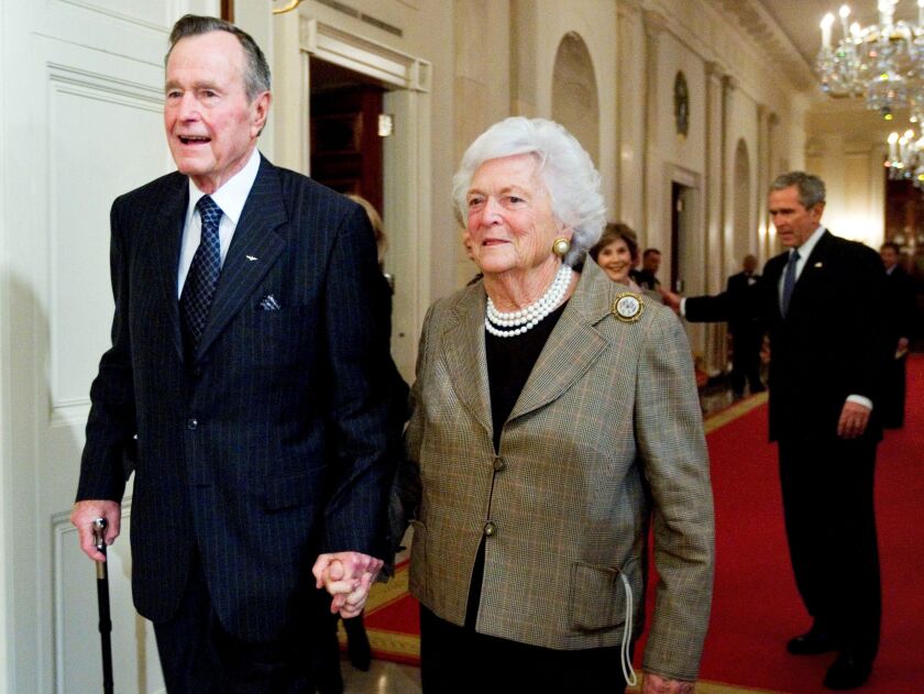 Former President George H.W. Bush, left, walks with his wife, Barbara Bush, followed by their son, President George W. Bush, and first lady Laura Bush to a reception in honor of the Points of Light Institute at the White House in 2009. The elder Bush died