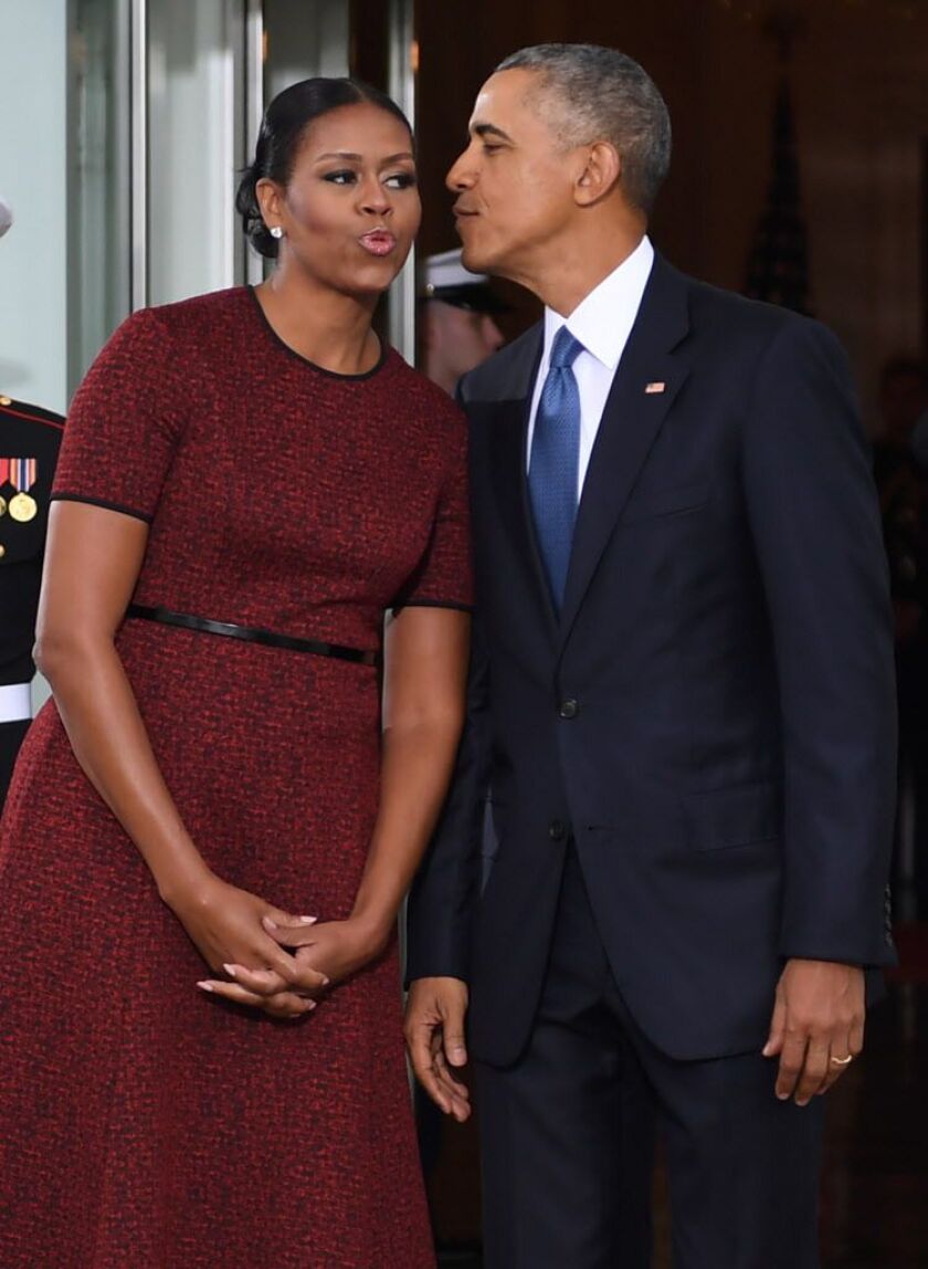 President Barack Obama and First Lady Michelle Obama kiss as they prepare to greet President-elect Donald Trump and his wife Melania to the White House in Washington, DC January 20, 2017. JIM WATSON/AFP/Getty Images