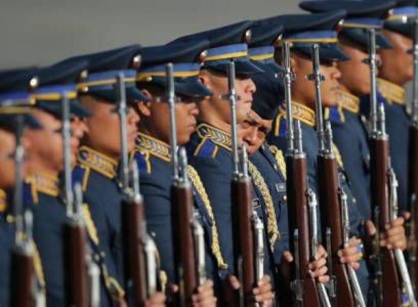 A Filipino trooper inspects the alignment of a guard of honor during rehearsals for the arrival of Indonesian President Joko Widodo at the Villamor Air Base in suburban Pasay, south of Manila, Philippines, Sunday, Feb. 8, 2015. (AP Photo/Aaron Favila)