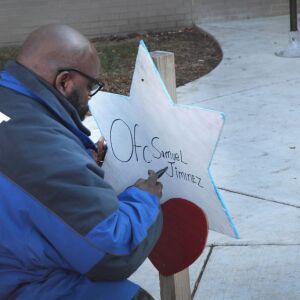 Donovan Price places a cross outside of the Wentworth station Tuesday. | Scott Olson/Getty Images