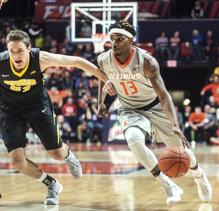 Illinois guard Tracy Abrams (13) tries to dribble past Iowa forward Nicholas Baer (51) in 2017.