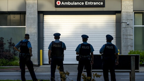 Chicago police officers wait outside the ambulance entrance of University of Chicago.