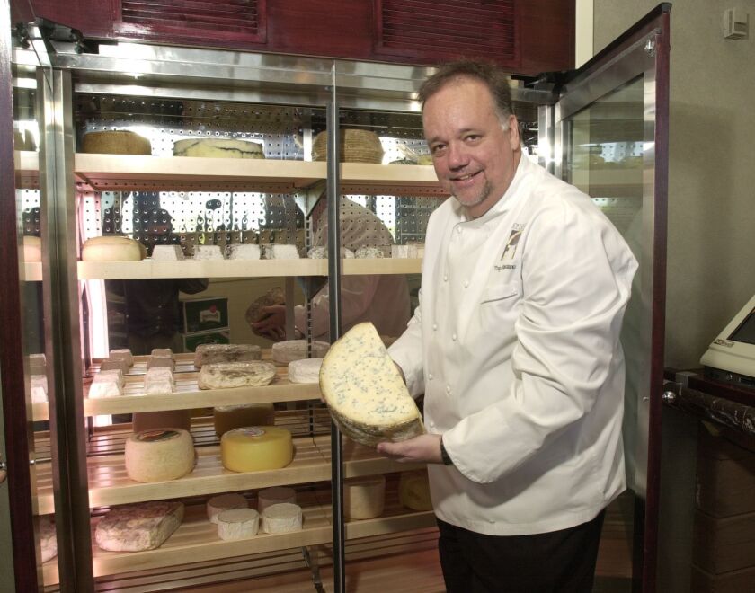 In this 2002 photo, Chef Tony Mantuano takes a half wheel of gorgonzola cheese from the cheese cave at Spiaggia. Photo by Jim Frost Sun-Times.