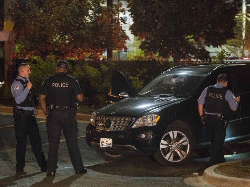 Chicago police investigate the vehicle of a woman who was shot Thursday night in the 8400 block of South Green. The vehicle was parked next to a police station in the 7900 block of South Halsted Street. | Tyler LaRiviere/Sun-Times
