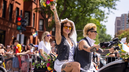 A recently married couple bikes down the parade route during the 55th Annual Chicago Pride Parade on June 28, 2026.