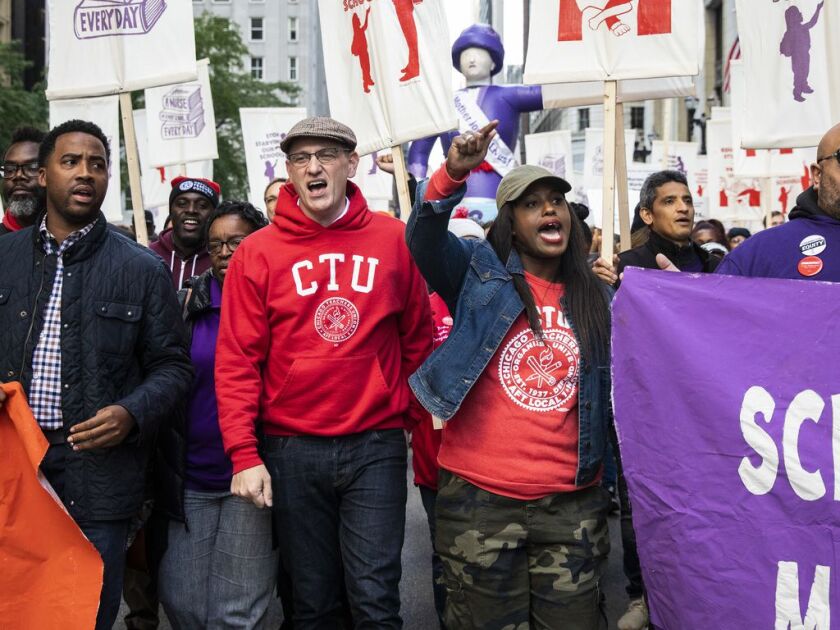 Chicago Teachers Union President Jesse Sharkey (front row, second from left) and Vice President Stacy Davis Gates (third from left) march with members of the CTU and SEIU Local 73 through the Loop after a rally, three days before the unions could walk off the job on strike, Monday afternoon, Oct. 14, 2019.