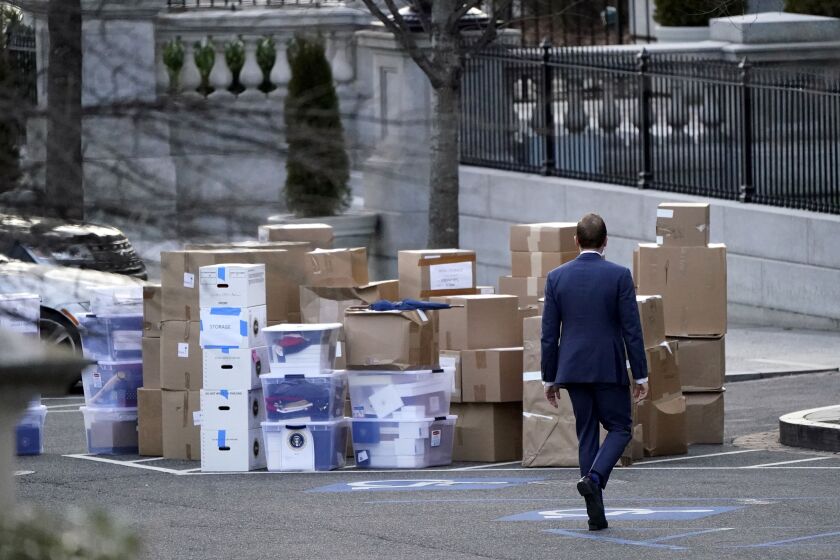A man walks past boxes that were moved out of the Eisenhower Executive Office Building, just outside the West Wing, inside the White House complex on Thursday, Jan. 14, 2021.