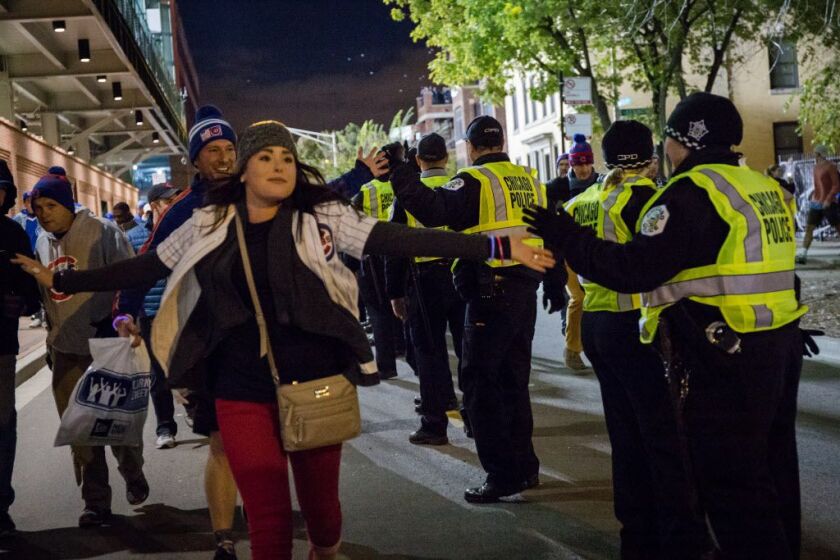 Cubs fans and police officers outside Wrigley Field celebrate the Cubs’s Game 5 World Series victory on Sunday. | Santiago Covarrubias / Sun-Times