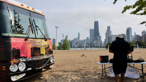 A DJ sets up at a beach party in August 2026.