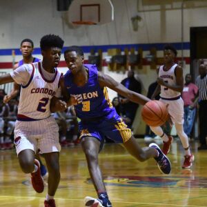 Curie’s Damari Nixon (2) grabs the arm of Simeon’s Antonio Reeves . Worsom Robinson/For the Sun-Times.