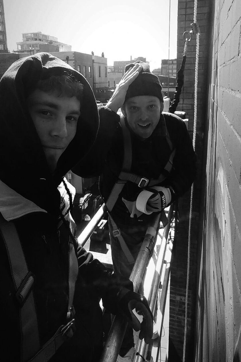 Artist Collin van der Sluijs (right) with Joseph Renda Jr., who helped work on the “Bloom to Doom” mural on South Michigan Avenue. They’re seen here working on a different project.