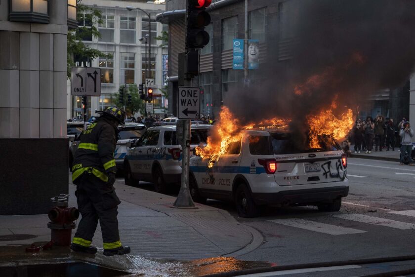 Chicago fire department respond to a Police vehicle set ablaze during a protest for George Floyd, Saturday, May 30, 2020. 