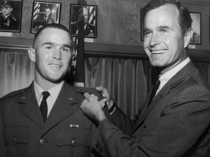 George H.W. Bush, right, is about to pin a lieutenant bar on his son, George W. Bush, after the younger Bush was made an officer in the Texas Air National Guard in 1968. Both men went on to serve as president of the United States. The elder Bush died at t