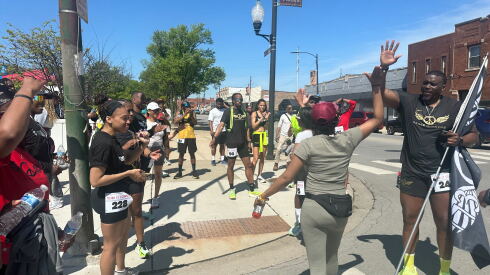 Peacerunners 773 members cheer on participants as they finish their journey along the 103rd Street corridor.