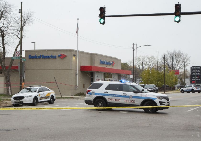 Police investigate Monday where two armored truck guards were shot at a Bank of America branch in Chatham. 