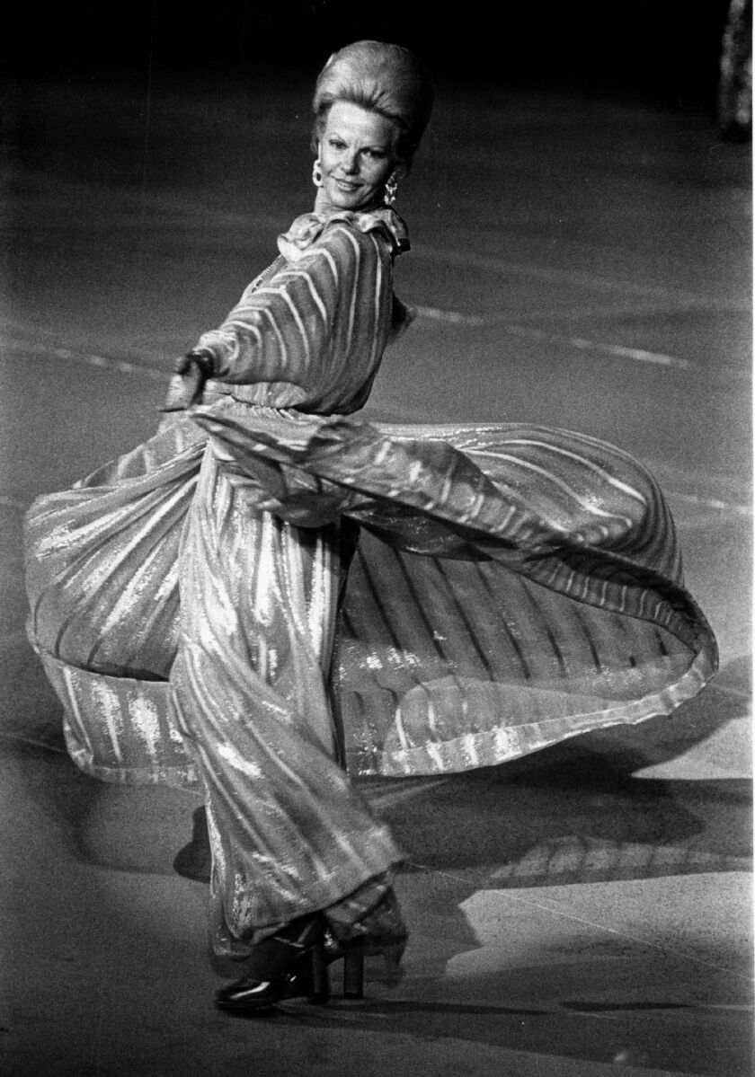Bonnie Swearingen twirling in satin stripe chiffon gown at a charity fashion event.