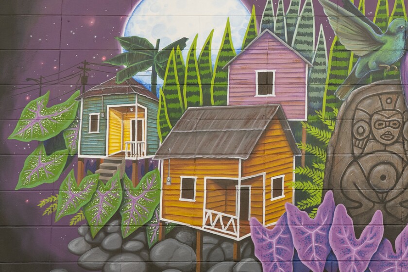 Small structures with pitched roofs — one blue, one orange and one pink — represent Rodriguez's home in Puerto Rico and the homes of his aunt and grandmother.