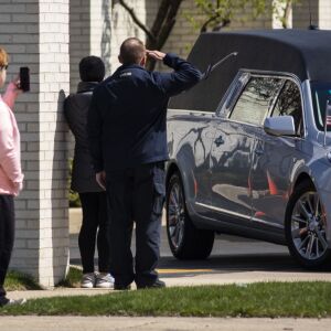 A man salutes as the hearse carrying Chicago Police Officer Officer Marco DiFranco leaves Cumberland Funeral Chapels and heads toward All Saints Catholic Cemetery & Mausoleum in Des Plaines, Thursday, April 9, 2020.